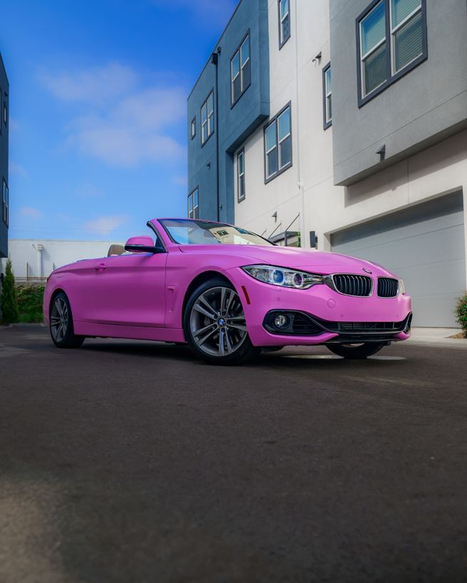 Pink wrapped BMW convertible parked outside